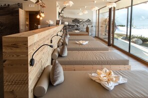 A modern spa room with wooden accents, a reception desk, and a large window with a mountain view.