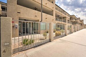 Un immeuble à plusieurs étages doté de balcons, d’un espace extérieur aménagé pour s’asseoir et d’un parking sécurisé.