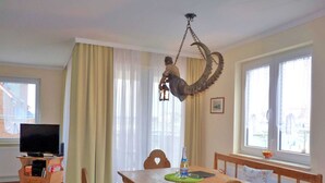Un comedor con una mesa de madera, sillas y una lámpara colgante.