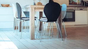 Une cuisine moderne avec une table en bois, des chaises et un luminaire suspendu.
