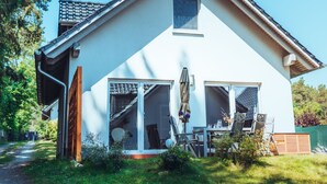 Une maison à deux étages, dotée d’un toit en pente, de grandes fenêtres et d’une porte de garage bien visible.