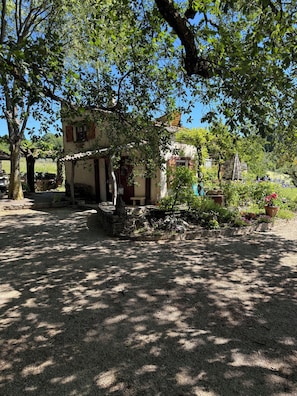 Ein rustikales Gebäude mit Steinfundament, Holztür und einer kleinen Veranda.