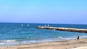 Vlak bij het strand, wit zand, ligstoelen, parasols