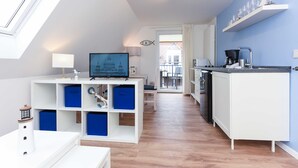 Eine moderne Küche mit weißen Schränken, einer schwarzen Arbeitsplatte und einem eingebauten Backofen.