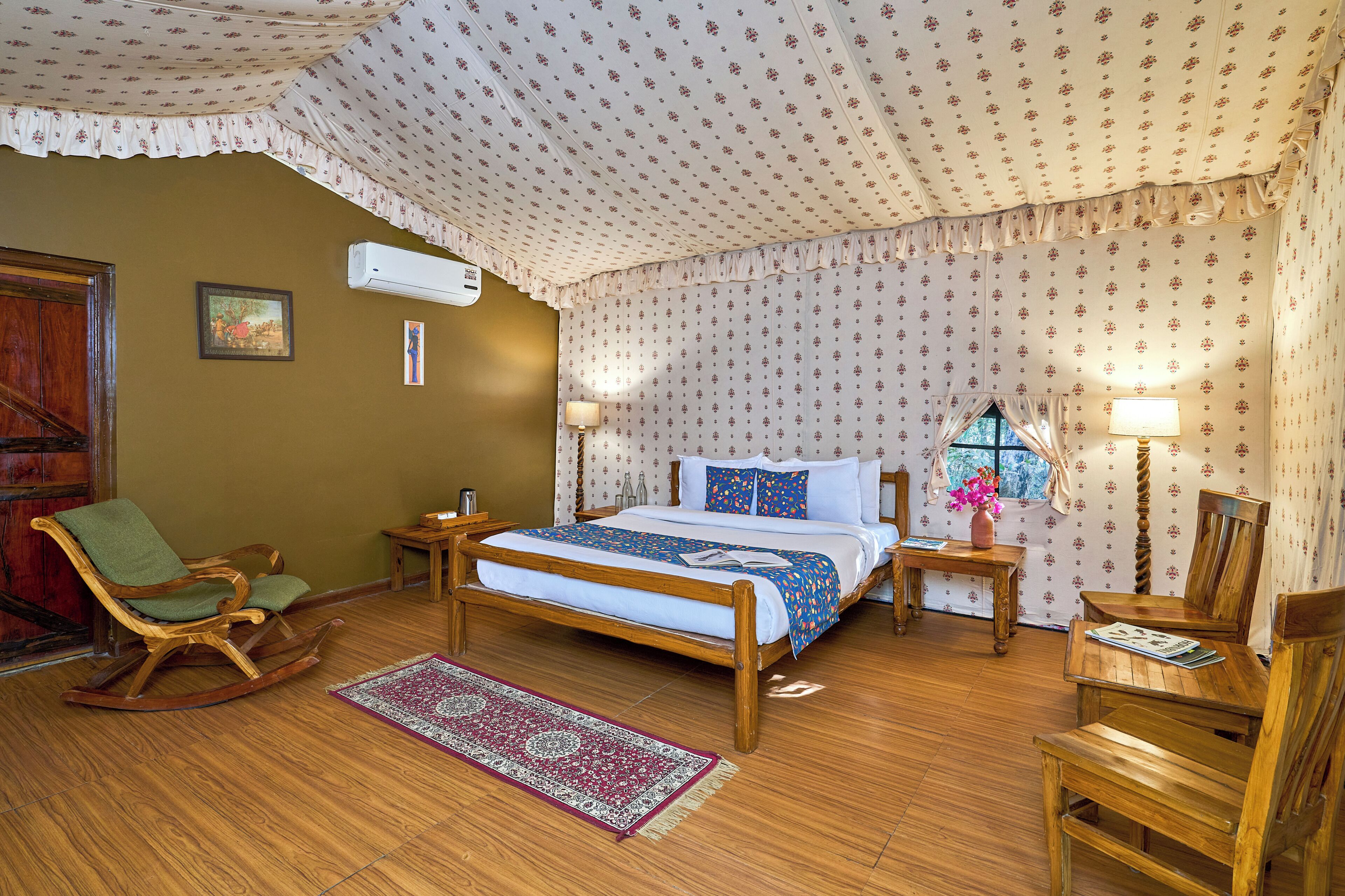 Ein Schlafzimmer mit einem hölzernen Bett, einem Schaukelstuhl, Nachttischen und einem Fenster mit Vorhängen.