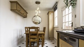 A kitchen with a dining table, chairs, a chandelier, and a dishwasher. - The cottage is a short walk to the Station, with trains to Liverpool / chester,  (Wirral, Merseyside)