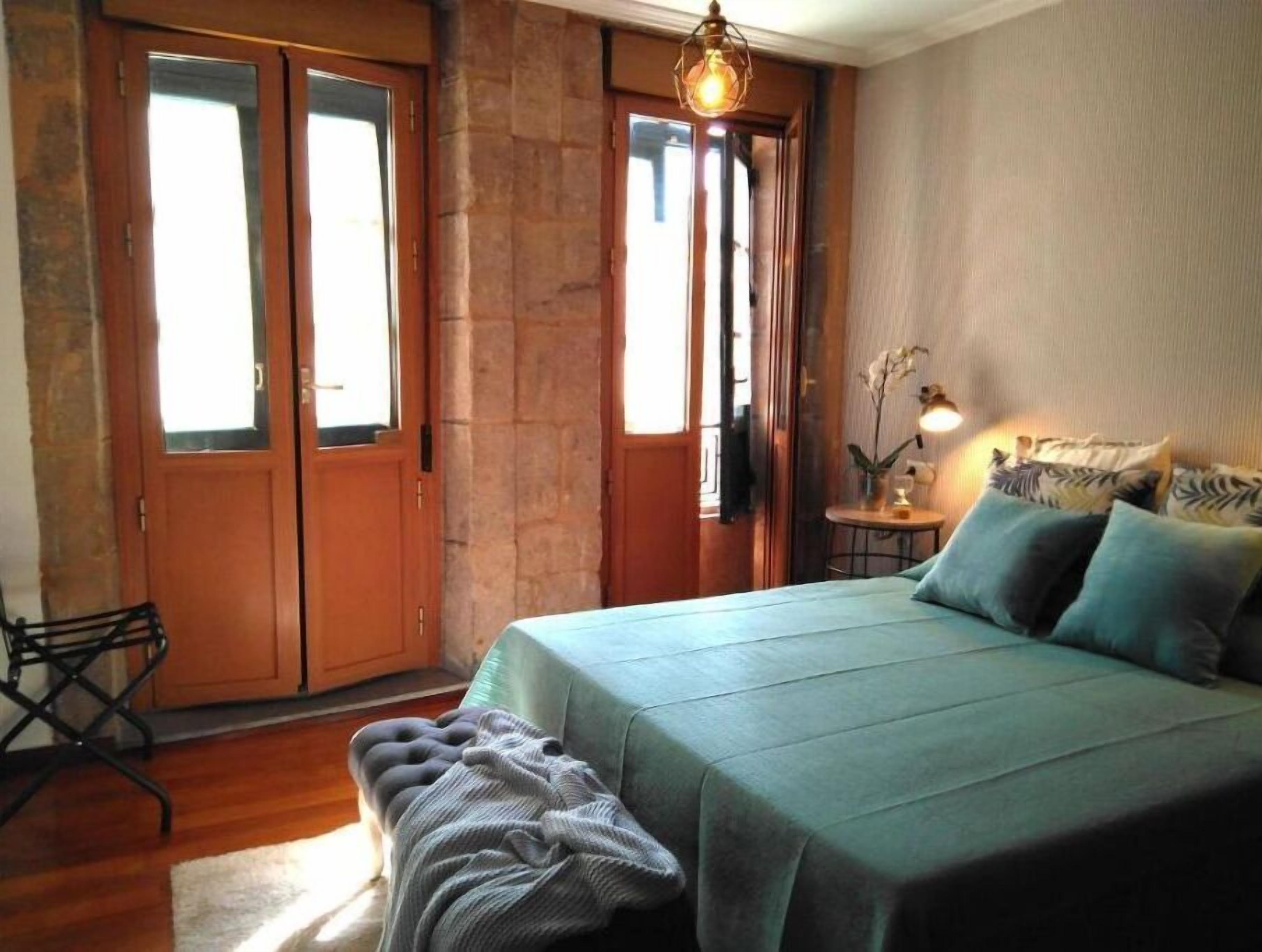 Un dormitorio con cama, una banca, un escritorio y una silla.