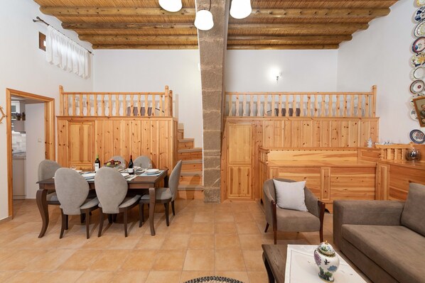 A wooden interior with a dining area, a staircase, and a living room. - Traditional House Leventis (Archangelos)