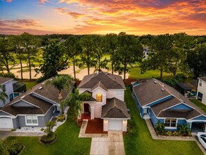 Un quartier résidentiel avec des maisons, une allée et, au loin, un terrain de golf.