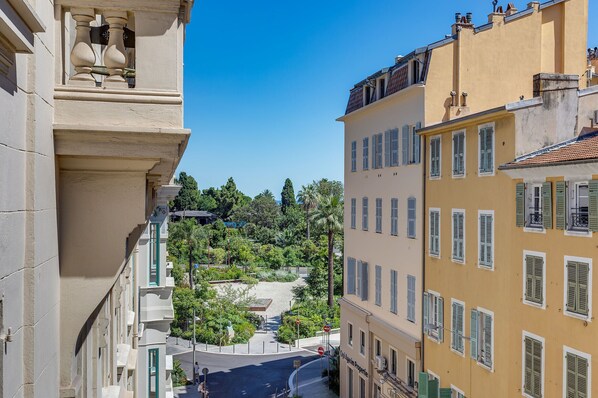 A street view with buildings, a clear sky, and a pathway leading to a hill. - SUEDE AP4207 by Riviera Holiday Homes (Niza)