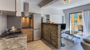 A modern kitchen with a built-in stove, a refrigerator, and a stone backsplash. - SUEDE  AP4207 by Riviera Holiday Homes (Niza)