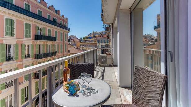 A balcony with a table, chairs, and a bottle of wine. - SUEDE  AP4207 by Riviera Holiday Homes (Niza)