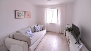 A modern living room with a sofa, a flat-screen TV, and a window with curtains. - A1 - Luxury apt in Center, Just 5min From Beach (Korcula)