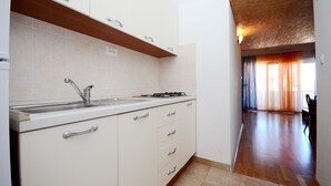 A kitchen with white cabinets, a stainless steel sink, and a gas stove. - A7 - apt With 2 Balconies, 5 min Walking to Beach (Podstrana)
