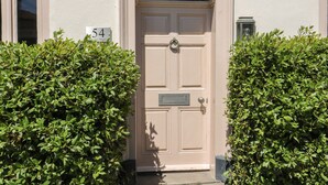 A beige door with a mailbox, number 54, and a small window above it. - 54 Bridge Street (Brigg)