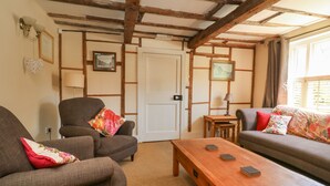 A cozy living room with two sofas, a wooden coffee table, and a door in the background. - 54 Bridge Street (Brigg)