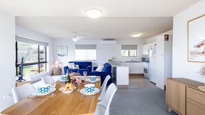 Un appartamento moderno con zona pranzo, cucina e soggiorno.