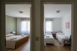 Une chambre d’hôtel avec un lit, une table de chevet, une chaise et une fenêtre avec des rideaux.