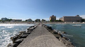 A pier leading to a beach with buildings in the background.