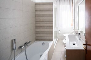 Een bad/douchecombinatie, een haardroger, een bidet, handdoeken