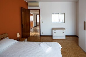 A hotel room with a bed, a nightstand, a dresser, and a mirror.