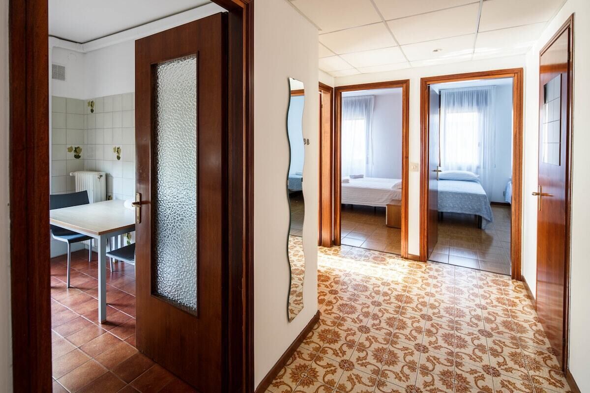 Ein Hotelzimmer mit Bett, Schreibtisch und einem durchgegangenen Tür sichtbaren Badezimmer.