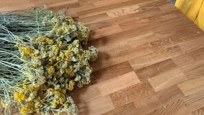 Et træbord med en buket gule blomster.