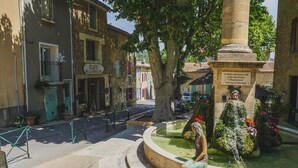 En gårdhave med en springvand, en statue og en café.