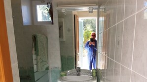 A bathroom with a sink, mirror, and shower. - Small apartment 15 minutes from Saint Florent overlooking CAP CORSICA (Santo-Pietro-di-Tenda)