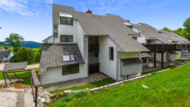 A modern two-story house with a sloped roof, a small attached garage, and a visible number '2' on the side. - Sunrise Timberline K2 fully renovated (Killington)