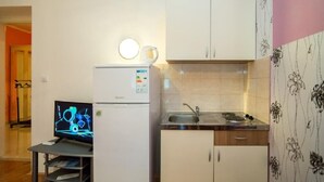 A compact kitchen with a refrigerator, a sink, and a small countertop. - Apartment Jasenka (Split)