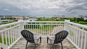 A balcony with two chairs and a view of a residential area and beach. - 3 Bedroom Townhome in Surf City (Surf City)