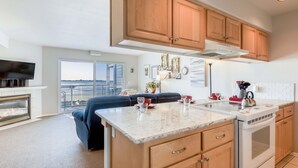 Una cocina moderna con armarios de madera, horno integrado y una isla grande con encimera de mármol.