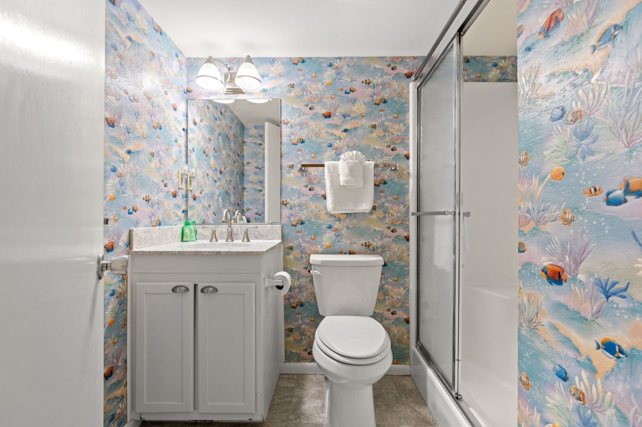 A bathroom with a toilet, sink, and shower.