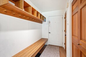 A hallway with a wooden bench, a door, and built-in shelving. - Riverside Dream | Short Walk to Main Street & Hike (Telluride)