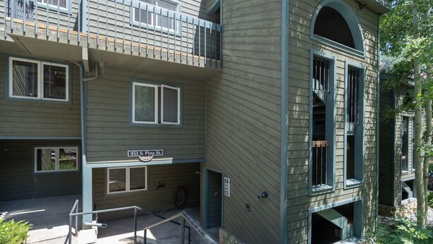 A multi-story building with a sign reading "451 S. Pine St." and a visible entrance with steps. - Riverside Dream | Short Walk to Main Street & Hike (Telluride)