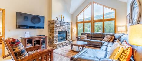 Spacious living area with vaulted ceilings, large flat screen HD TV, gas fireplace, ample seating and access to the private balcony.