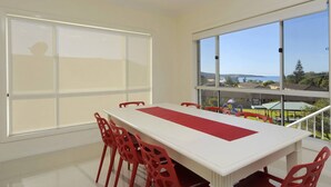 Una stanza spaziosa con un'ampia finestra che si affaccia su una zona residenziale e un corpo d'acqua.