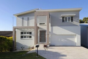 A modern two-story house with a garage, a front door, and a mailbox.