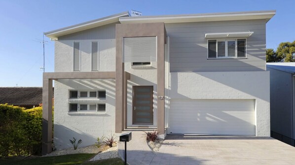 A modern two-story house with a garage, a front door, and a mailbox.