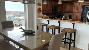 Una cucina moderna con mobili in legno, un piano di lavoro in granito e un'area bar con sgabelli.