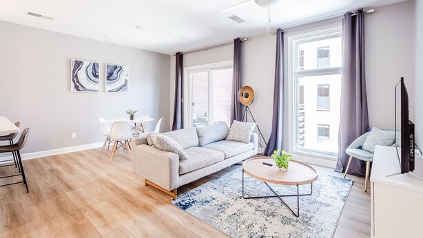 Ein modernes Wohnzimmer mit Sofa, Couchtisch und Kunstwerk an der Wand.