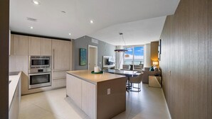 A modern kitchen with built-in appliances, a central island, and a dining area with a view. - Ocean front 2 bed 15th floor Hollywood Miami (Hollywood)