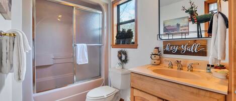 A bathroom with a bathtub, toilet, and sink.
