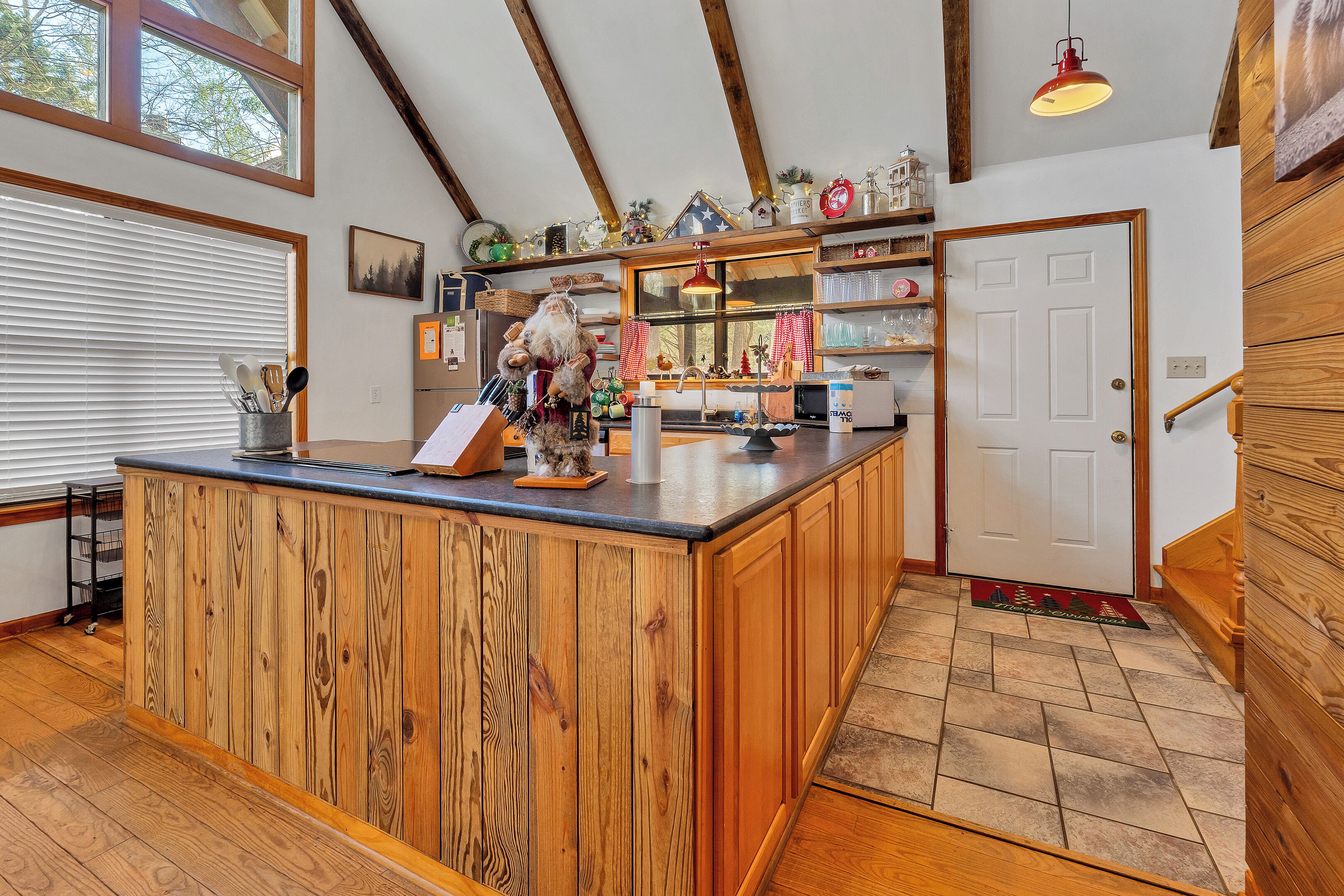 A kitchen with wooden cabinetry, a central island, and a window with blinds.