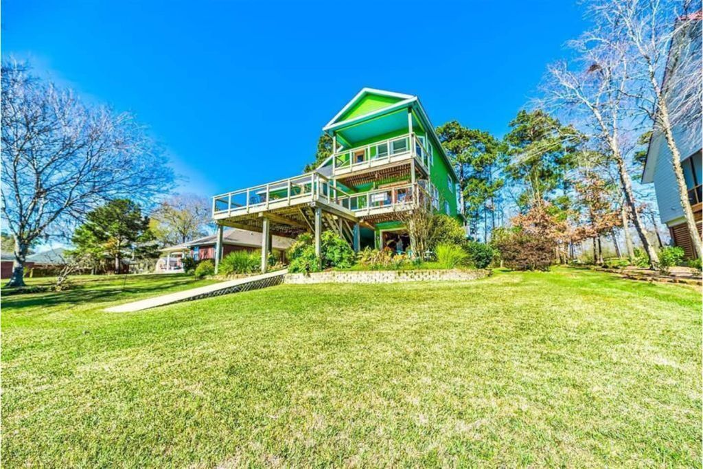 A two-story house with a green roof and a balcony.