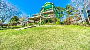A two-story house with a green roof and a balcony.
