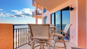A balcony with wicker furniture and a view of the beach. - SeaChase 1002W BY Liquid Life (Orange Beach)