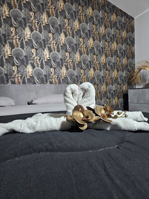 Un lit avec une couverture blanche et un coussin décoratif.
