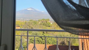 A balcony with a view of a mountain and surrounding greenery. - La Punta (San Giovanni la Punta)